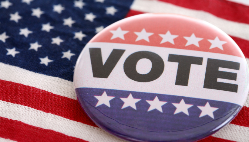 button pin reading vote laying on an American flag